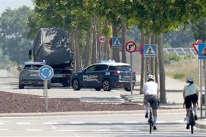 La comitiva amb les dues grues que transporten el ‘papa mòbil’ a la seva sortida de la terminal corporativa de l'aeroport . ACN / Guillem Roset