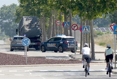 La comitiva amb les dues grues que transporten el ‘papa mòbil’ a la seva sortida de la terminal corporativa de l'aeroport . ACN / Guillem Roset