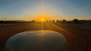 Posta de Sol del dia de Sant Joan des d'un camp de blat segat amb les bales de palla des de Vilafranca del Penedès. Jordina Jané