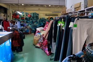 Roba penjada i de fons les bosses de roba per reciclar. ACN / Lourdes Casademont 