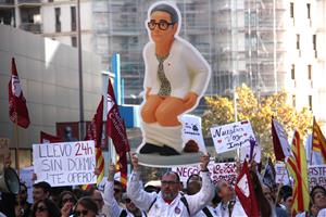 Un assistent a la manifestació alça la figura de la consellera de salut de la Generalitat, Olga Pané. ACN / Clàudia Corbella