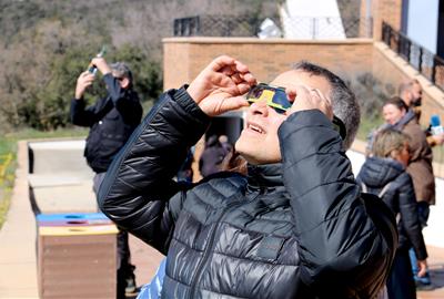 Un home observa l'eclipsi solar amb ulleres homologades des del Parc Astronòmic del Montsec. ACN / Alba Mor