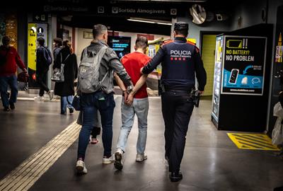 Un mosso de paisà i un uniformat s'enduen un detingut al metro de Barcelona en el marc del macrodispositiu 'Kanpai' . ACN / Jordi Borràs