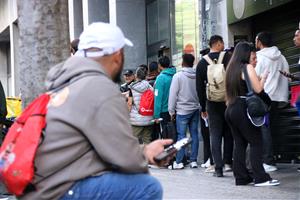 Una persona espera el seu torn a la cua amb cita prèvia de l'OAC per regularitzar la seva situació. ACN / Albert Hernàndez