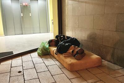 Una persona sense llar dormint davant d'un portal. ACN / Jordi Pujolar